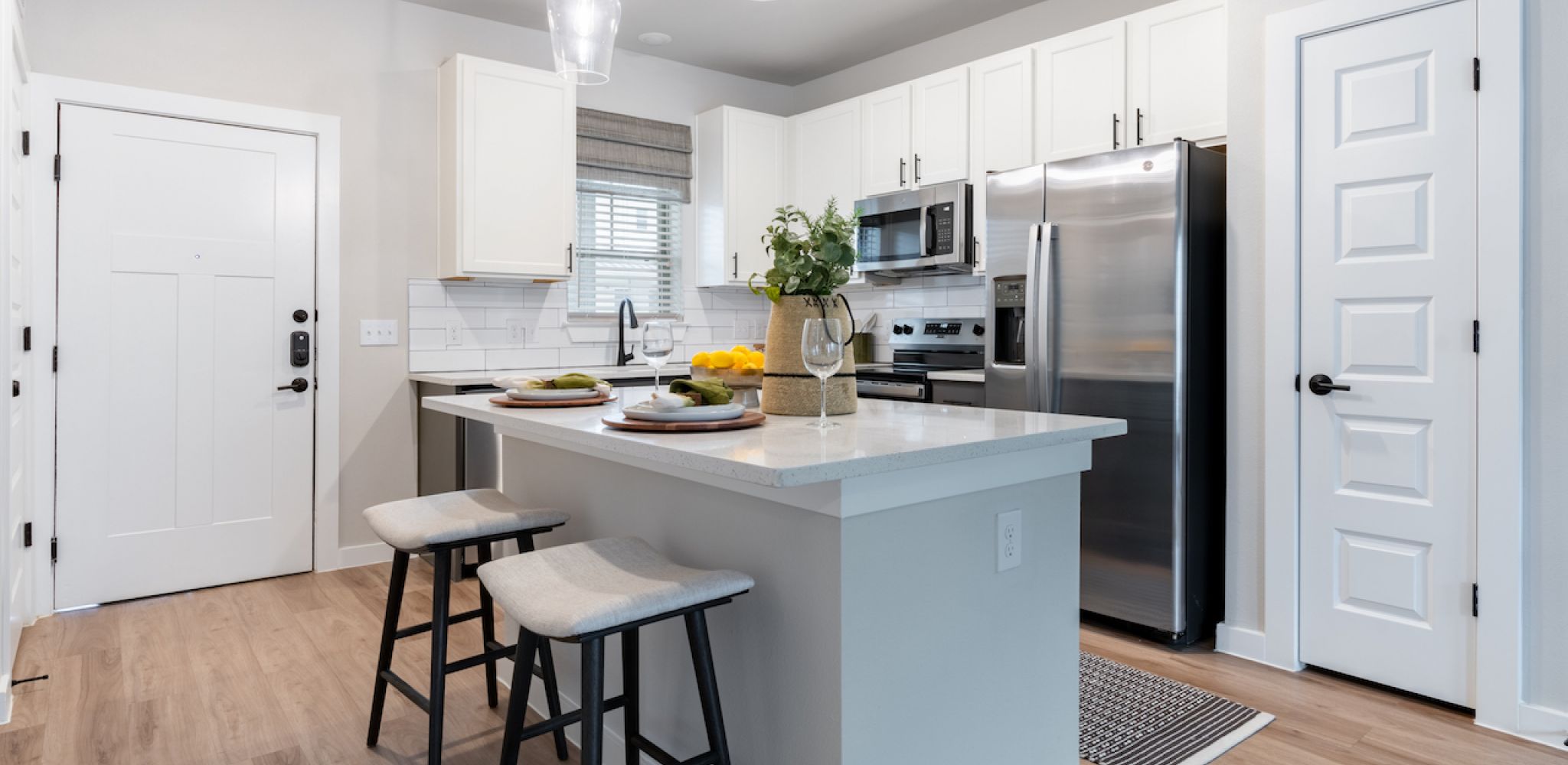 Artesia at Medina Valleykitchen with white cabinets, a kitchen island, and stainless steel appliances.